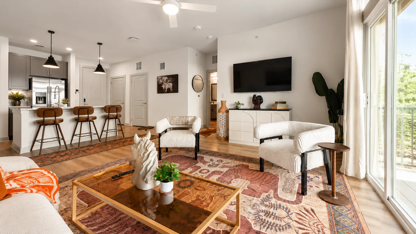 Bright furnished living room with city skyline view, workspace, sofa and suitcase ready for move-in